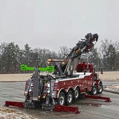 a tow truck with a crane attached to it's flatbed in the snow