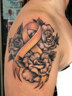 a woman with a tattoo on her shoulder has a yellow ribbon in the shape of a rose