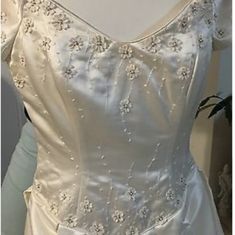 the back of a wedding dress on display in a shop window, with white fabric and beading