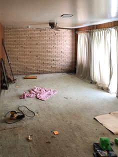 an empty living room is shown in the process of being remodeled with carpet and other items scattered around