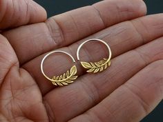 * Tiny Leaf Hoop Earrings in gold-tone with sterling silver hoops. * 17mm diameter hoops. * One pair. Click here for solid sterling version: https://www.etsy.com/listing/747682553/tiny-leaf-hoop-earrings-solid-sterling Our tiny silver hoop earrings feature a cascade of gold-tone olive leaves and are inspired by love of nature and peace. The olive branch has been worldwide symbol of peace since ancient times. You might never want to take off these comfy little sleeper earrings! ------------------ Statement Piece Jewelry, Olive Leaves, Symbol Of Peace, Sleeper Earrings, Mother Of Pearl Earrings, Handmade Gifts For Her, Eco Friendly Jewelry, Olive Leaf, Sterling Silver Hoop Earrings