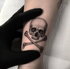 a skull and crossbones tattoo on the arm