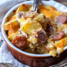 a close up of a bowl of food with sausage and potato casserole in it