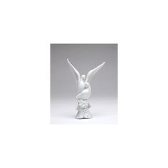 a white bird statue sitting on top of a table