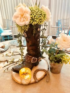 an arrangement of flowers and boots on a table