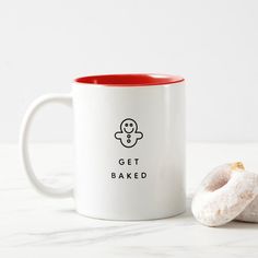 a white and red coffee mug with a donut on the side that says get baked