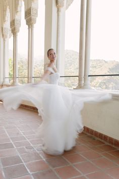 a woman in a white dress is posing for the camera