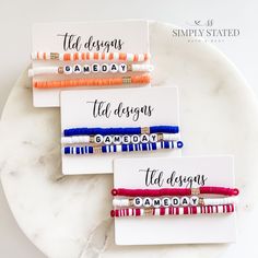 four bracelets with different sayings on them sitting on a white marble plate next to each other