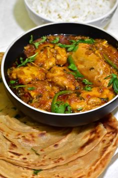 a bowl of chicken curry next to some pita bread