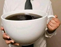 a man in a tie holding a bowl of coffee