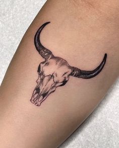 a bull skull tattoo on the leg