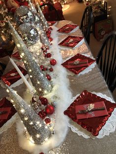 the table is set with red and silver decorations