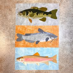 three fish are depicted on an orange, blue, and green piece of art paper