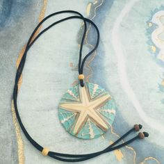 a blue and white necklace with a wooden starfish on it's back end