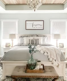 a bedroom with a bed, nightstands and a chandelier above the bed