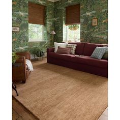 a living room with green wallpaper and brown rugs on top of the floor