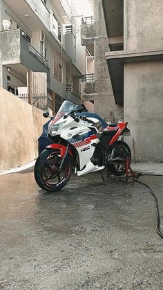 a red and white motorcycle parked in front of a building