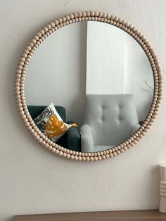 a round mirror hanging on the wall above a couch