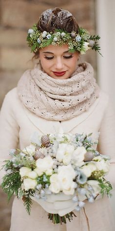 a woman wearing a scarf and holding a bouquet