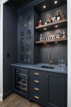 a kitchen with dark blue cabinets and gold pulls on the cupboards, along with an oven