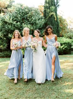 the bridesmaids are all wearing blue dresses and holding bouquets in their hands