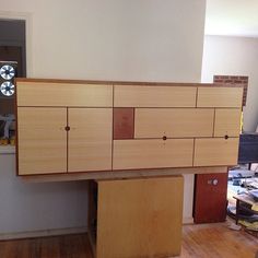 an unfinished cabinet is sitting in the middle of a room with hard wood flooring