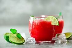 two glasses filled with watermelon and limeade next to ice cubes