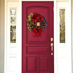 a red front door with a wreath on it