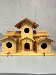 a wooden birdhouse with several holes in it's roof and two on each side