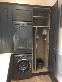 a washer and dryer in a small room with wood flooring on the walls