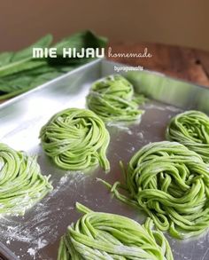 some green noodles are on a pan and ready to be cooked