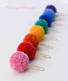 a row of multicolored pom - poms sitting on top of each other