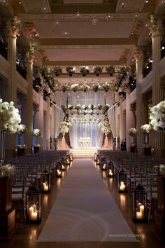 the aisle is decorated with candles and flowers for an elegant wedding ceremony at the grand america hotel