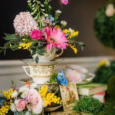 a table topped with lots of different types of flowers and vases filled with plants