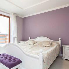 a bedroom with purple walls and white furniture