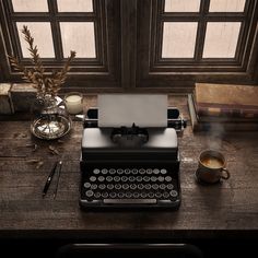 an old fashioned typewriter sitting on top of a table next to a cup of coffee