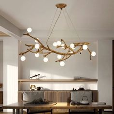 a dining room table with chairs and lights hanging from it's ceiling over it