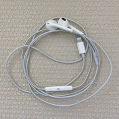 two ear buds connected to each other on a table with a white cord in the middle