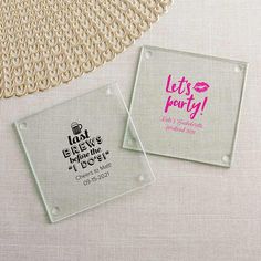 two personalized glass coasters sitting next to each other on a table with a doily