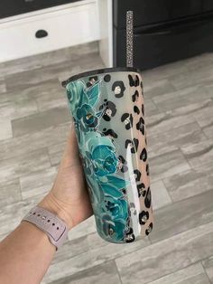 a person holding up a cup with an animal print design on the bottom and sides