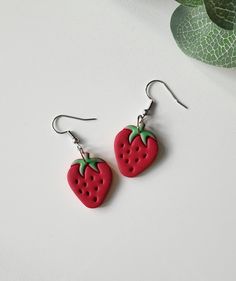 pair of strawberry shaped earrings on white background