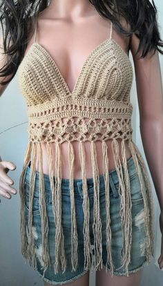 a female mannequin wearing a crochet top with fringes on it