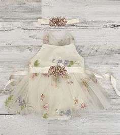 This listing is for an ivory with floral/butterfly embroidery styled tulle  Bobo style romper with options of a "one" applique sash and matching headband to complete the look! Such a sweet and delicate romper which is made with a light pink tulle  top and a sheer tulle skirt attached.  The snaps allow for easy diaper changing and comfort!   **This listing is for any of the following:   *Romper ONLY *1 Romper with Sash (sash ribbon with "one" appliqué attached  colors of "one" silver-rose gold-gold) *1 Headband * SET of 3 (1 Romper/Sash/Headband) SIZES: 6-9 Months- 18-20 lbs. 9-12 Months- 20-22 lbs. 12-18 Months- 22-26 lbs. 18-24 Months- 26-30 lbs. -colors can be customized! Just convo me with your ideas! Checkout another matching headband! https://www.etsy.com/listing/652358466/boho-baby-h Cream Bubble Romper For First Birthday In Spring, Spring Baptism Cream Bubble Romper, White Bubble Romper For Spring Cake Smash, White Bubble Romper For Cake Smash In Spring, Pink Tulle Top, Boho 1st Birthday, Tulle Top, Cake Smash Outfit, Butterfly Embroidery