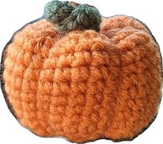 an orange crocheted pumpkin sitting on top of a white surface