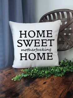 a pillow that says home sweet mothering home on it next to a potted plant