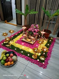 an arrangement of fruits and flowers on the floor