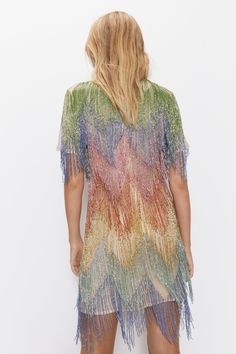 Vibrant ombré rainbow fringe detailing   Lightweight, sheer overlay with sequin embellishments   Relaxed shift silhouette with short sleeves   Crew neckline and above-knee length  This dazzling rainbow fringe shift dress from Warehouse brings statement style to your evening wardrobe. Cut from a lightweight sheer fabric with vibrant ombré fringe cascading from the hem, this dress makes a bold fashion statement. The relaxed shift silhouette features short sleeves and a crew neckline for versatile layering.   Sequin embellishments catch the light beautifully, adding high-impact glamour. Pair this dress with metallic heels and minimal jewellery to complement the rainbow beaded fringing. It's perfect for making an entrance at parties, events and nights out on the town. The thigh-grazing leng Knee Length Evening Dress, Rainbow Fringe, Fringed Dress, Minimal Jewellery, Occasion Dresses Wedding, Sheer Overlay, Oasis Fashion, Metallic Heels, Rainbow Beads