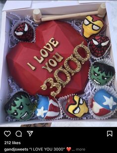 an open box filled with cupcakes decorated like avengers and the words i love you dad