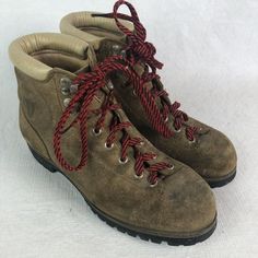 a pair of brown hiking boots with red laces