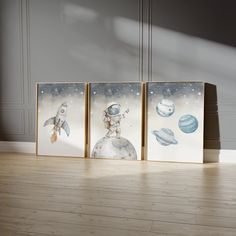 three paintings on the floor in front of a wall with space and planets painted on them